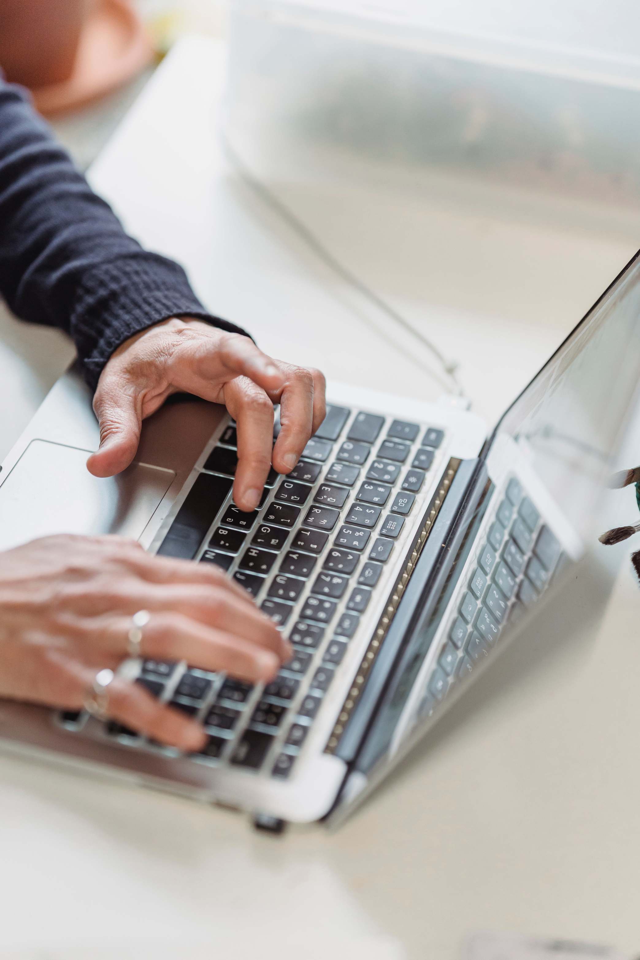Hände tippen auf einer Laptop-Tastatur